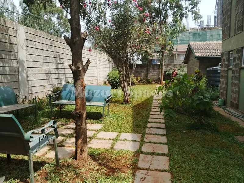 Seating area under a tree with stepping-stone paths, KMA residence